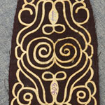 Орнамент из рыбьей кожи, наклеенный на ткань. Сложная зооморфная символика. Предназначался для орнаментирования рукавиц или боковой части традиционного нанайского халата – саркал